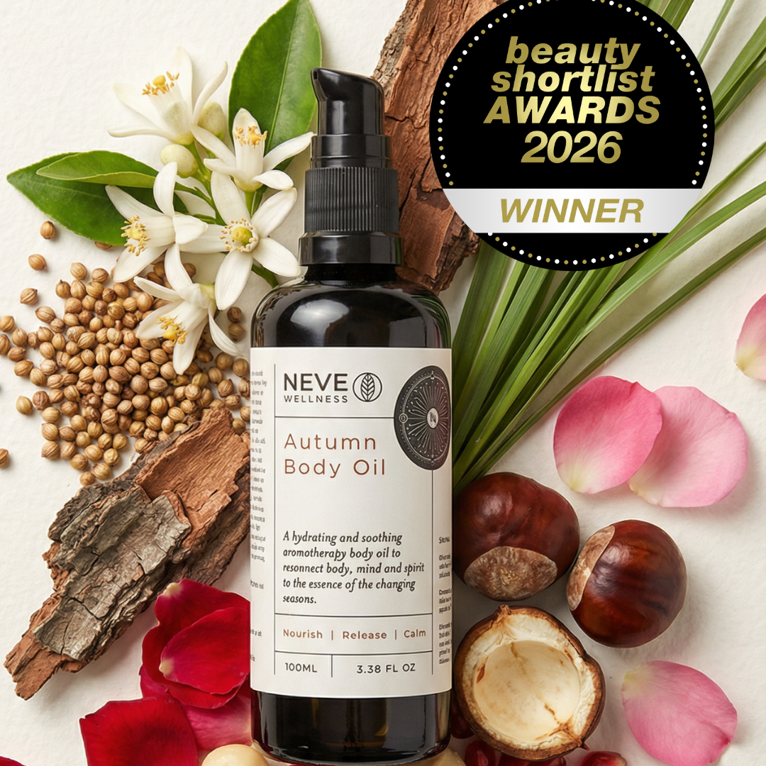 Neve Wellness Autumn Body Oil bottle with natural elements on a light background, including flowers and nuts.